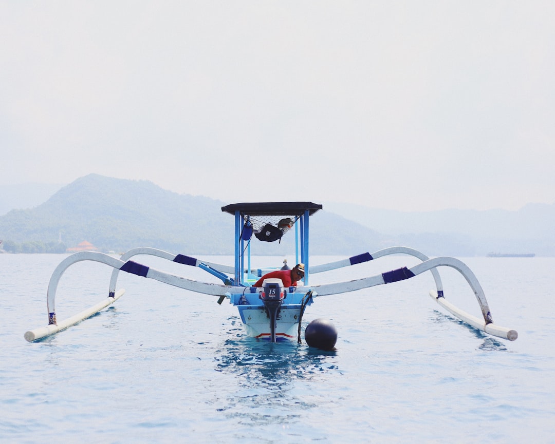 white and blue boat in body of water close-up photography