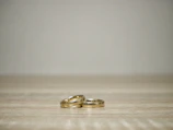 Flat lay of trendy gold rings and delicate stackable bands on a marble table.