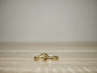 Minimalist display of gold and silver jewelry on white surface.