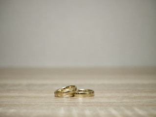 A minimalist shot of wedding rings resting on a plain white surface.