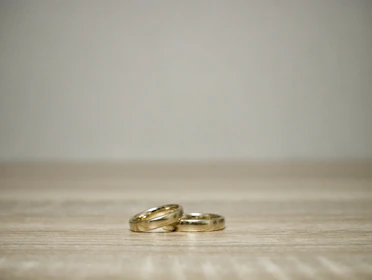 A collection of minimalist Korean rings arranged artfully on a wooden surface.