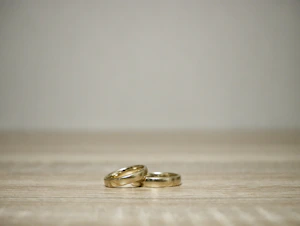 Stacked gold-plated rings arranged elegantly on a marble surface with subtle shadows.
