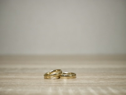 Elegant 10k gold rings stacked together on a wooden surface with natural light