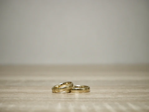A minimalist gold ring set displayed on a smooth black marble surface.