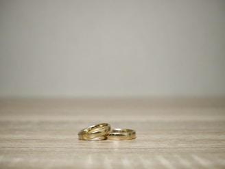 Close-up of elegant gold and silver rings arranged on a rustic wooden surface