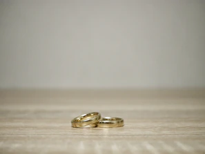 Flat lay of trendy gold rings and delicate stackable bands on a marble table.