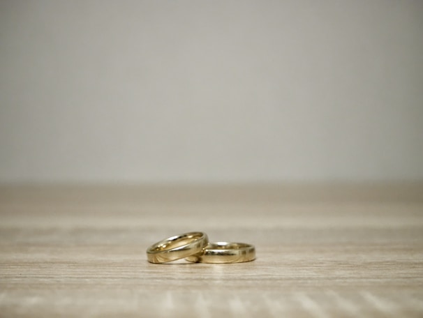 Close-up of elegant gold and silver rings arranged on a rustic wooden surface