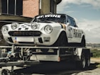 white and black coupe on trailer during daytime