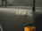 A close-up view of a military vehicle with the number 6834 displayed on a matte dark green surface. The image includes an orange indicator light and parts of the vehicle's structure.