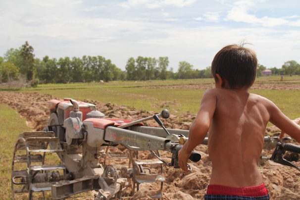 Young trainees engaged in hands-on agricultural machinery training under expert guidance.