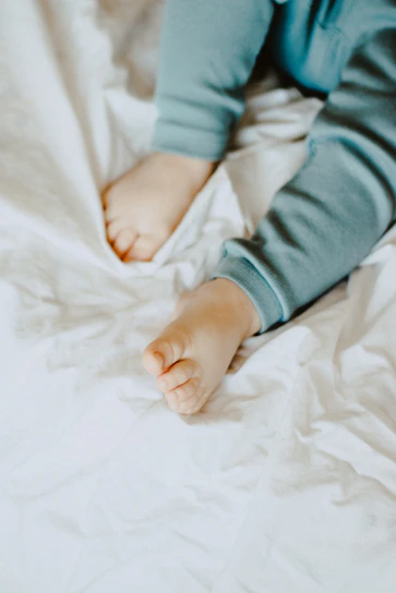 Close-up of soft, cozy toddler pajamas with playful animal prints laid out on a bed.