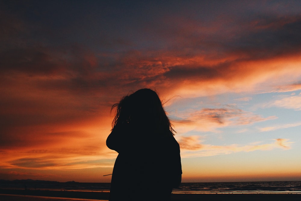 person standing near seashore photo – Free Silhouette Image on Unsplash
