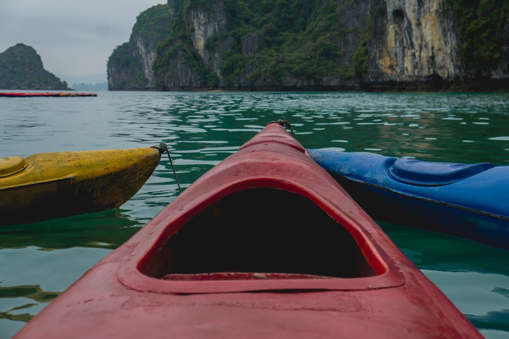 three red, yellow, and blue canoe in body of water during daytime