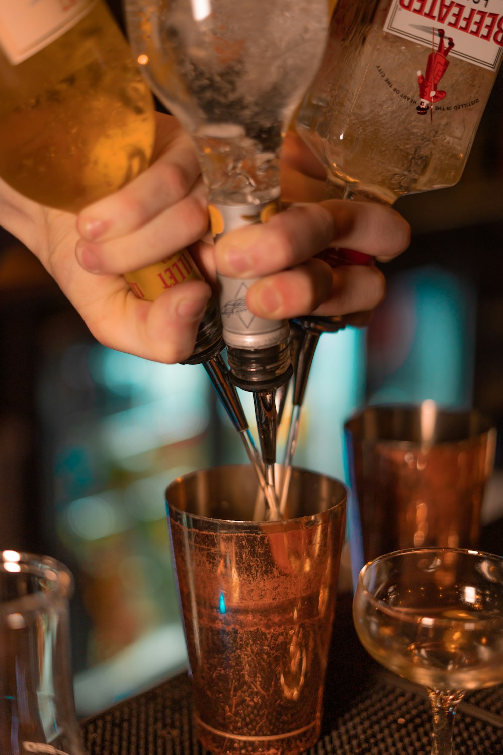 person pouring beverages in one cup