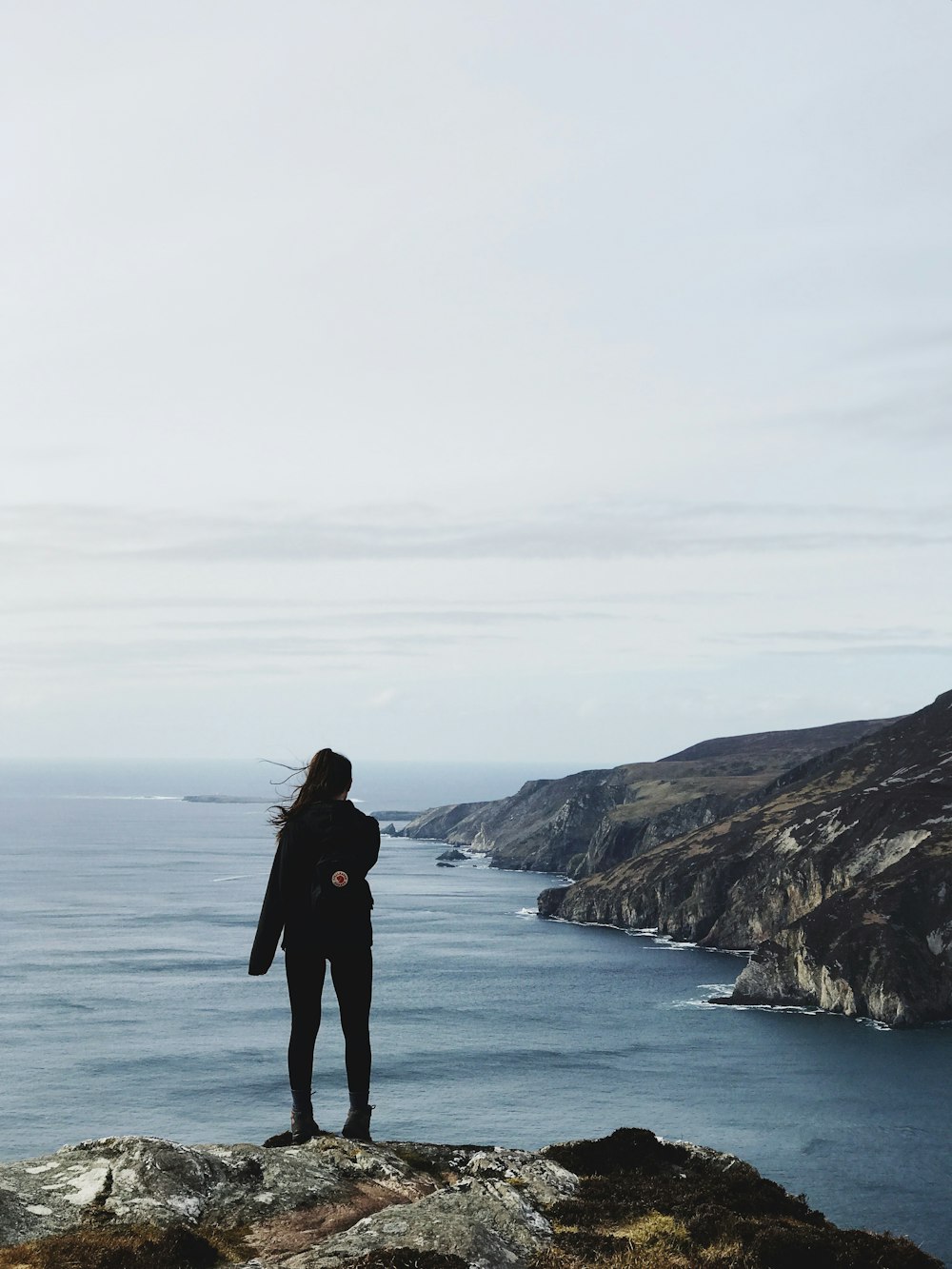 woman standing on cliff