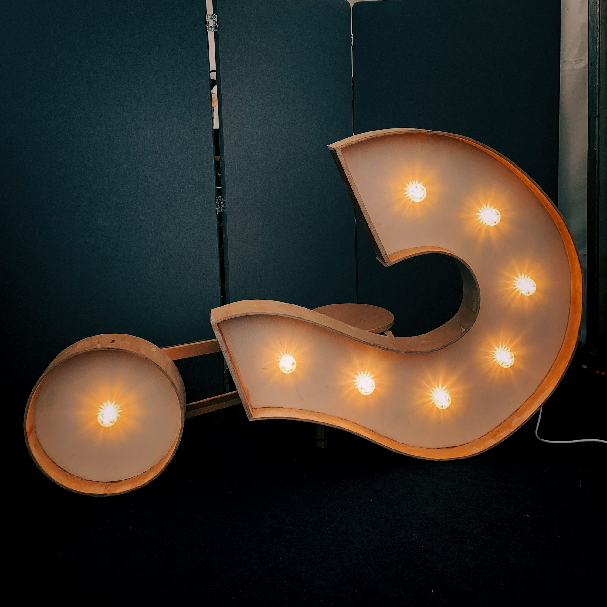 A large, lit question mark symbol, turned 90 degrees on its side.