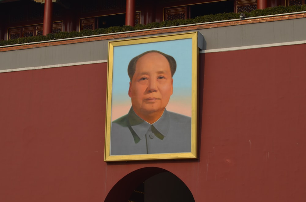 man wearing blue shirt photo on wall