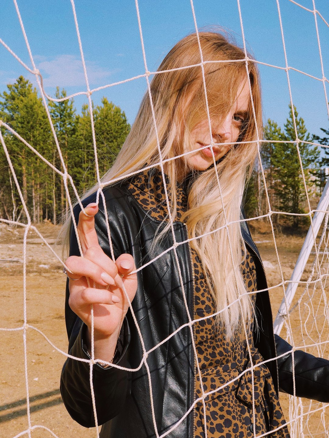 woman standing behind soccer goalie