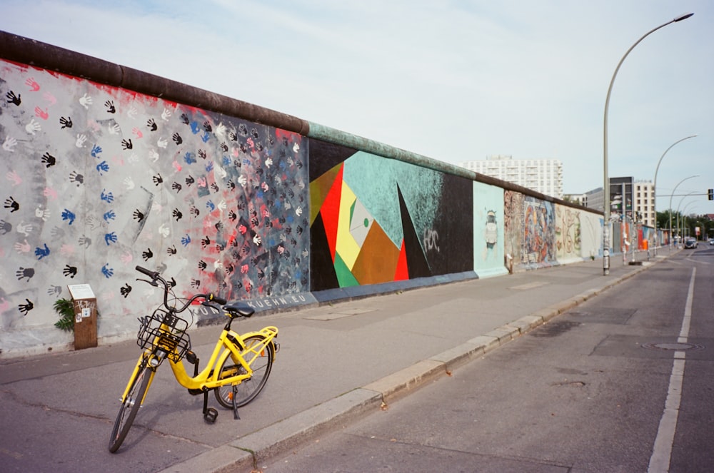 bicicleta amarela perto da parede