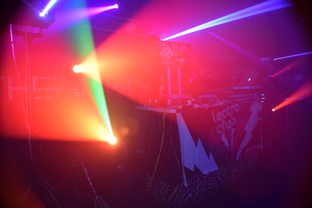 Un escenario de conciertos con luces de colores brillantes y una cabina de DJ
