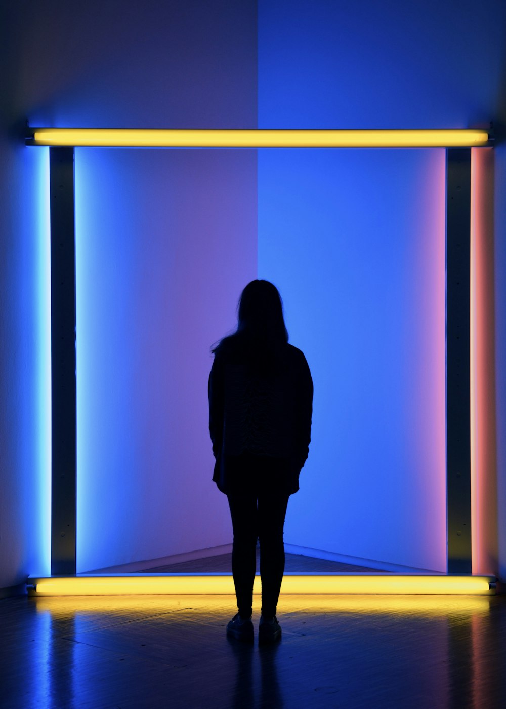 silhouette of woman standing beside yellow light bars