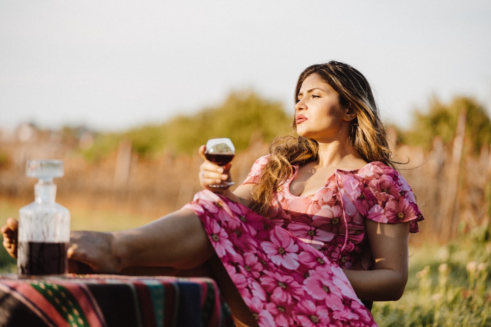 woman sitting in picnic table holding wine glass