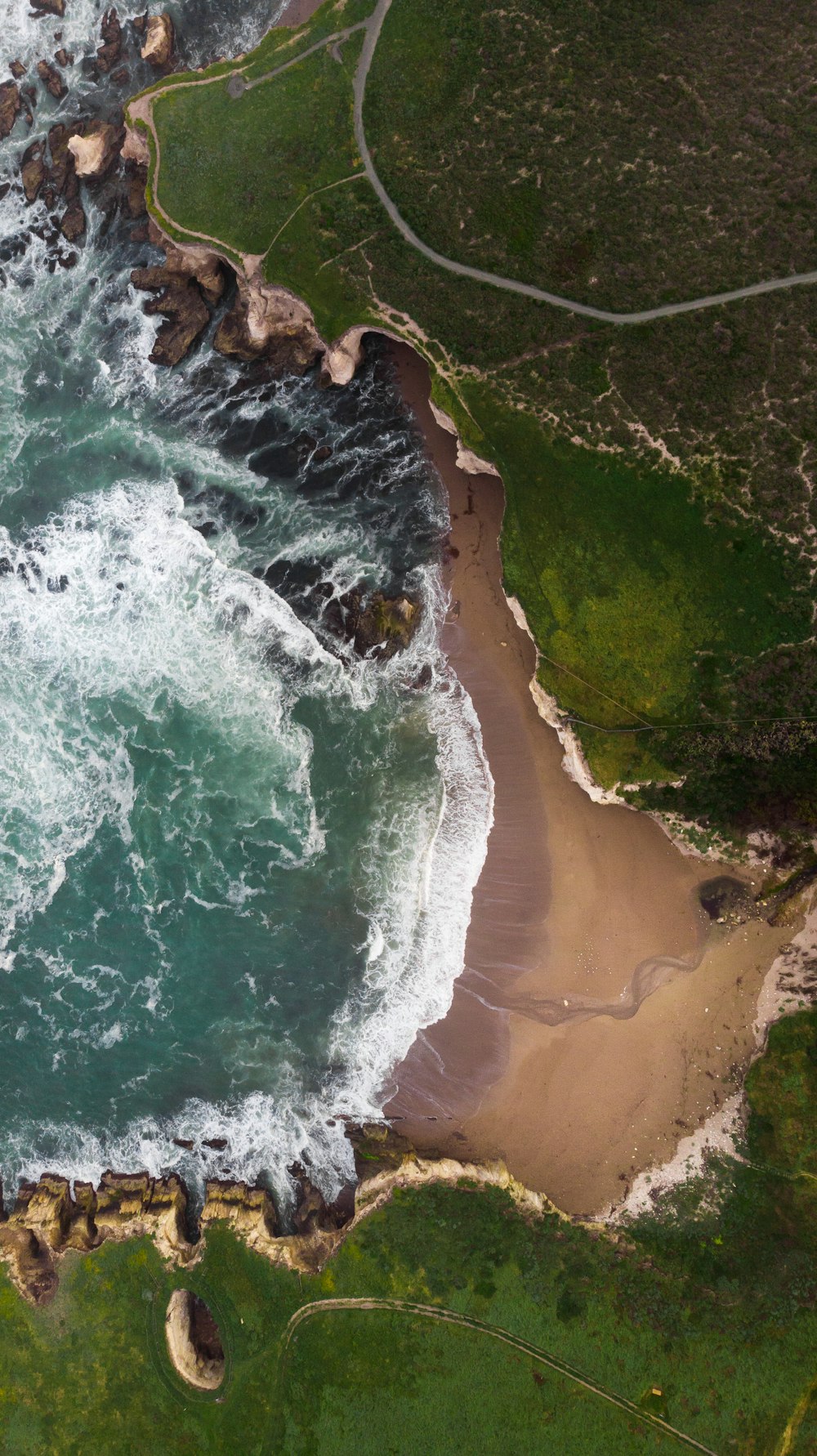 aerial view of ocean and green cliff