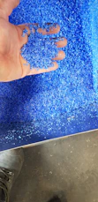 Close-up of recycled plastic pellets being processed into graphene material.