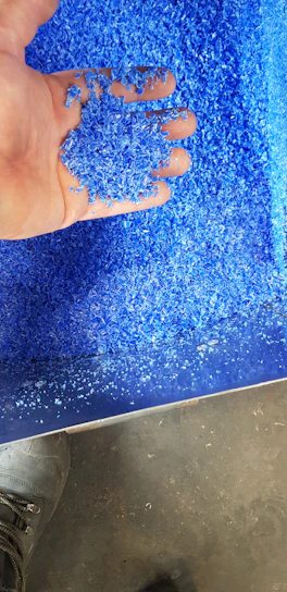 Close-up of colorful plastic resin pellets in a factory setting