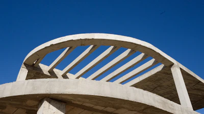 Wide shot of a partially completed masonry building under a clear sky.