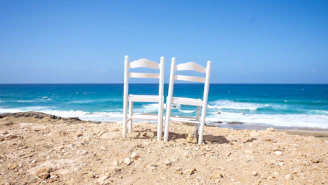 white wooden chairs on shore