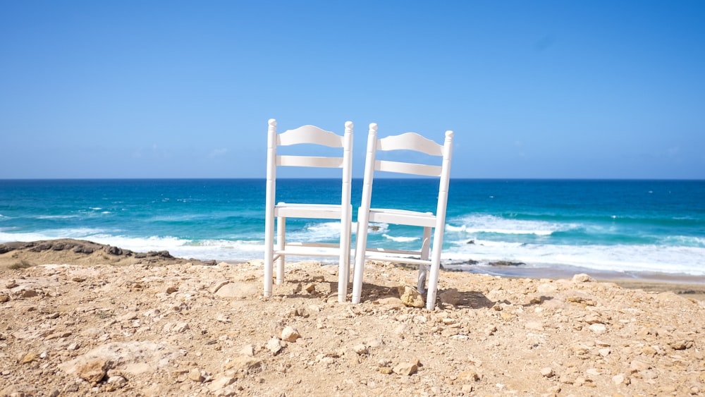 white wooden chairs on shore