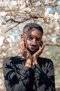 man in black long-sleeved shirt under white-petaled flowers