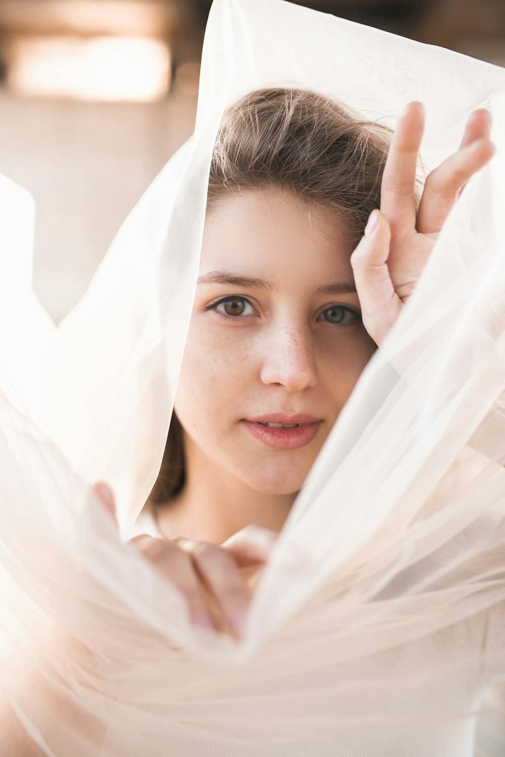 Femme souriante recouverte d’un textile blanc