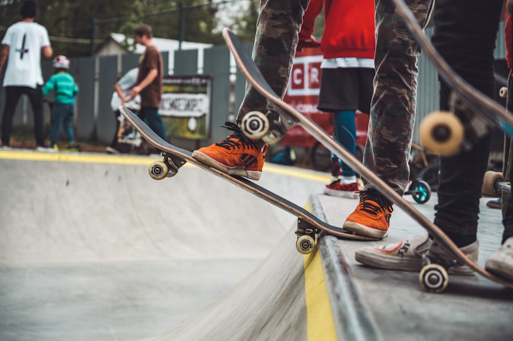 three men on skateboards standing on top of vert ramp