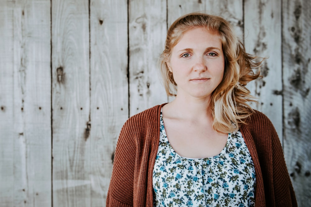 woman standing beside wooden wall