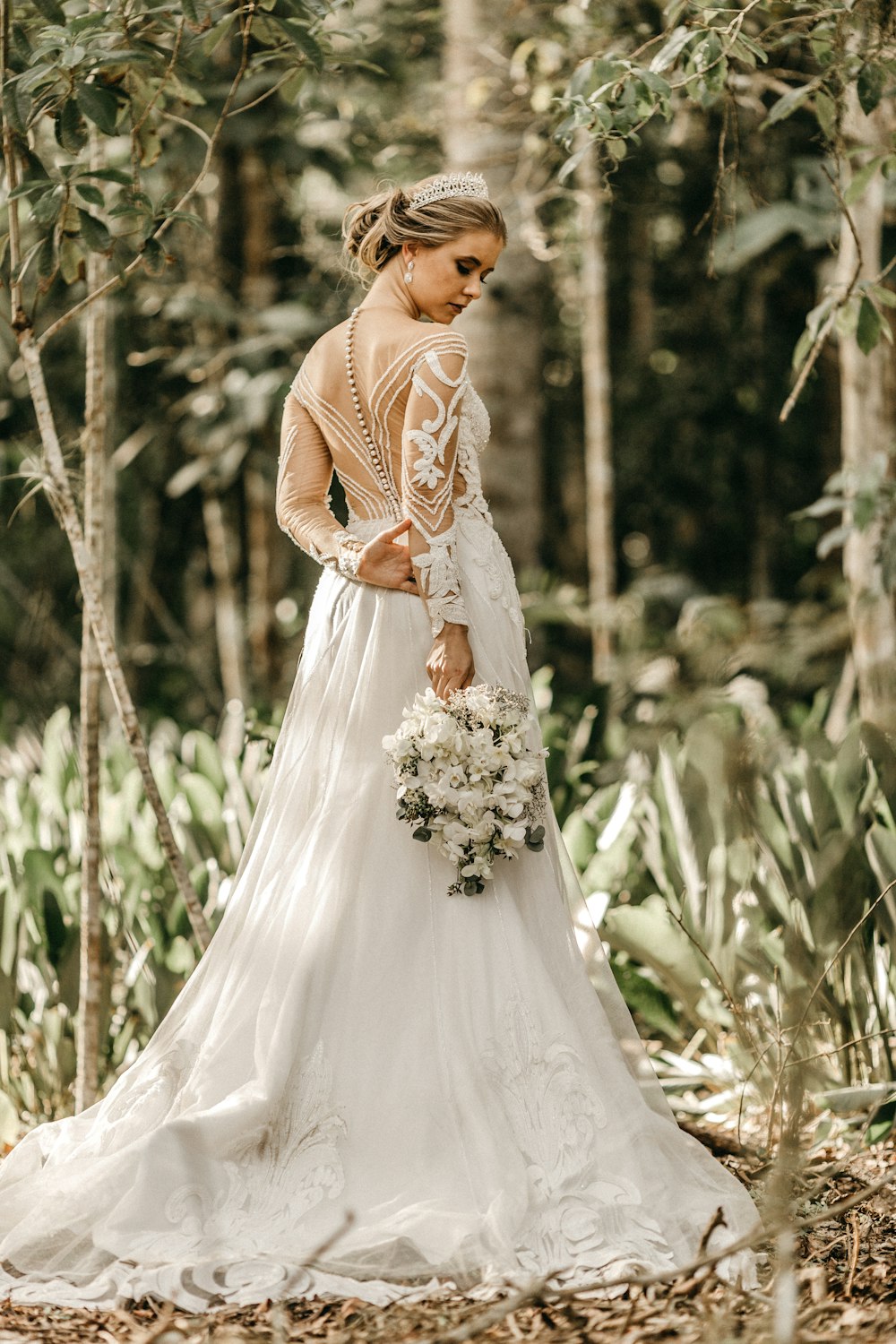 donna che tiene il bouquet di fiori bianchi durante il giorno