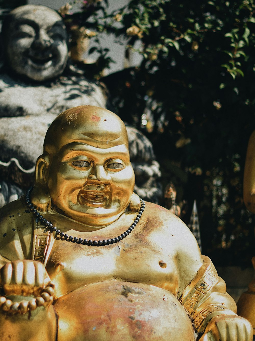 Budai figurine near statue