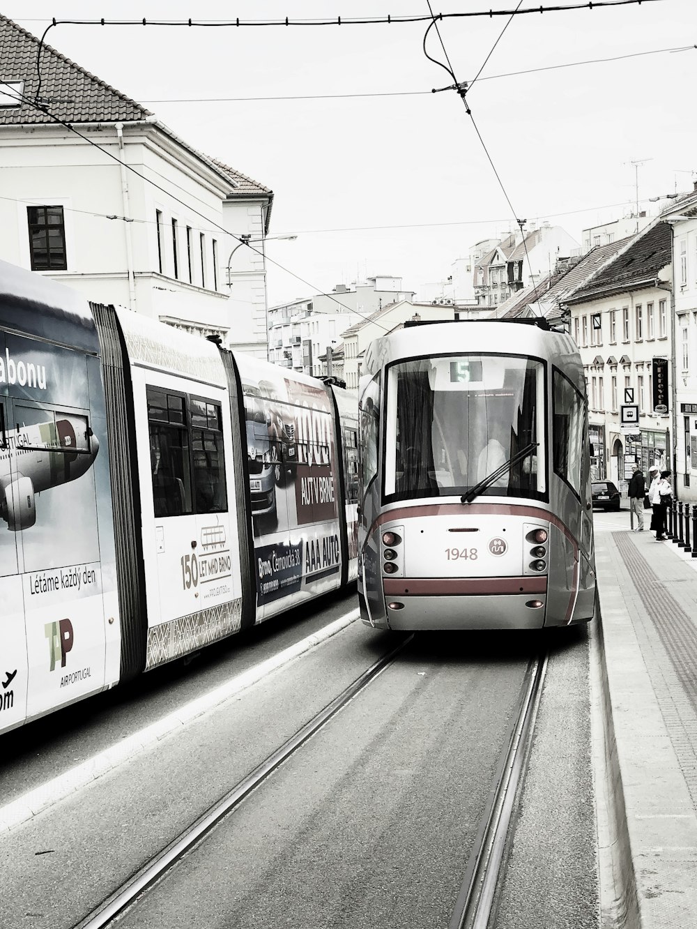 few people walking near train beside buildings