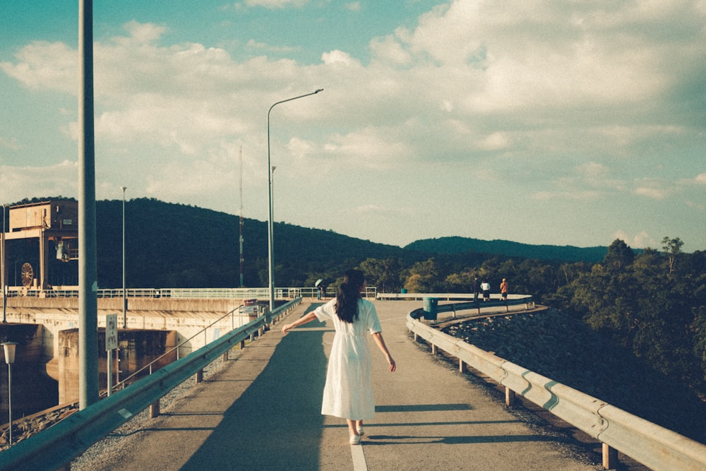 woman in white dress walking in road