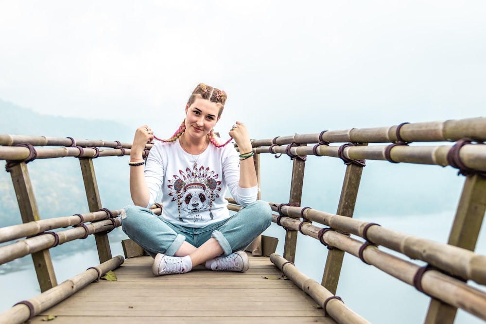 woman sitting on wooden floor with bamboo railings