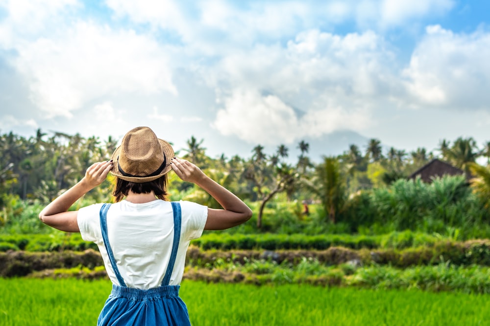 woman facing rice field and coconut trees