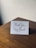 A close-up of a handwritten thank you card with elegant calligraphy on a wooden table.