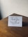 A close-up of a handwritten thank you card with elegant calligraphy on a wooden table.