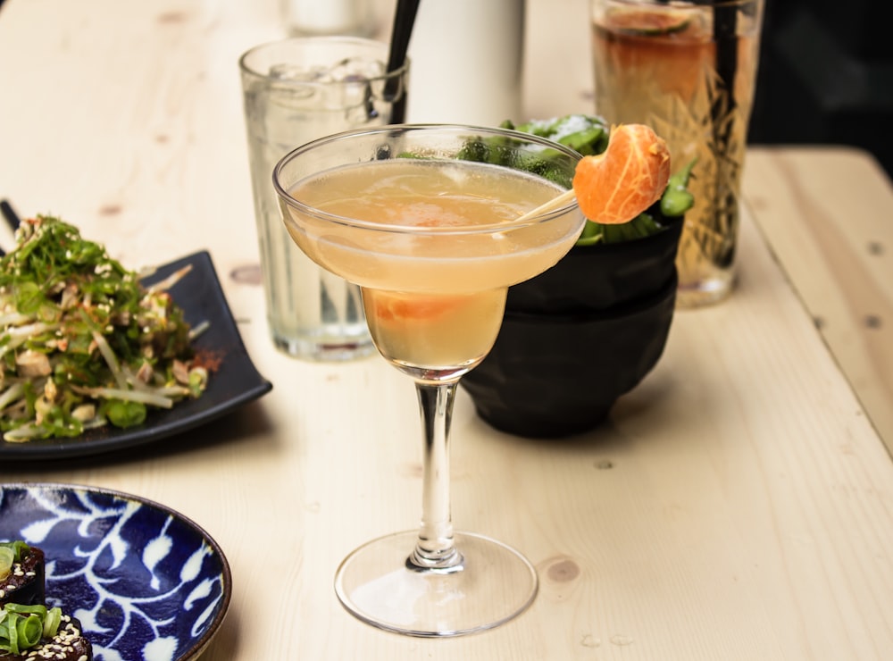 beverage filled clear cocktail glass on wooden surface