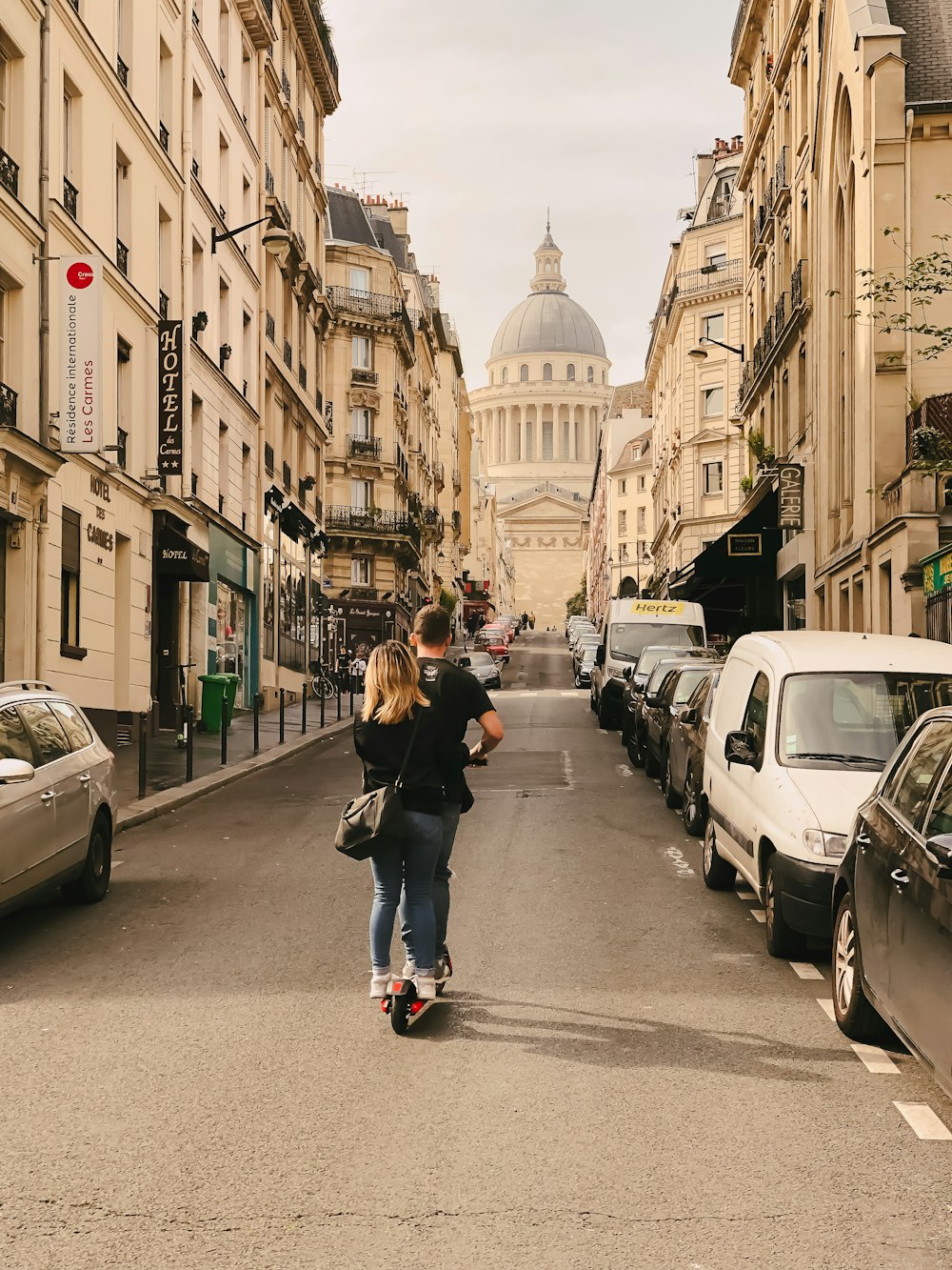 man and woman riding kick scooter