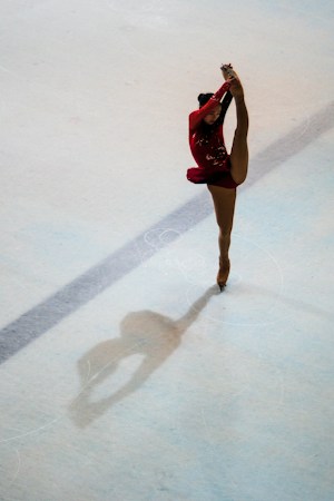 A figure skater performs a graceful move on an ice skating rink during a show