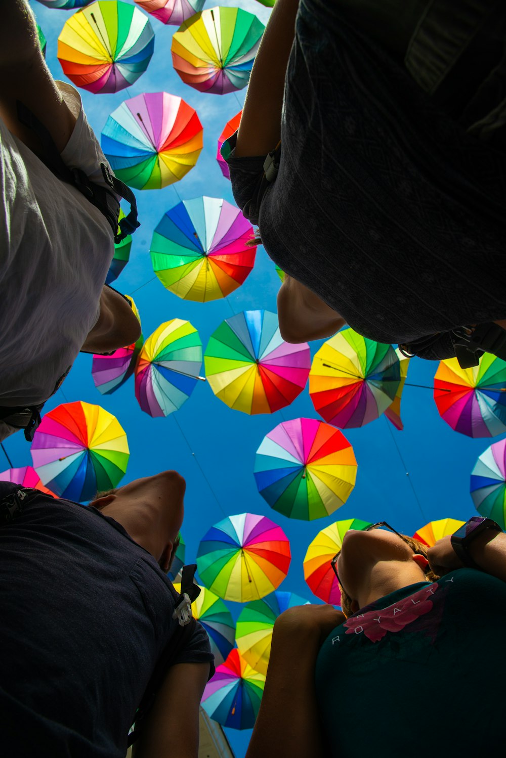 low-angle photo of people under colorful umbrellas