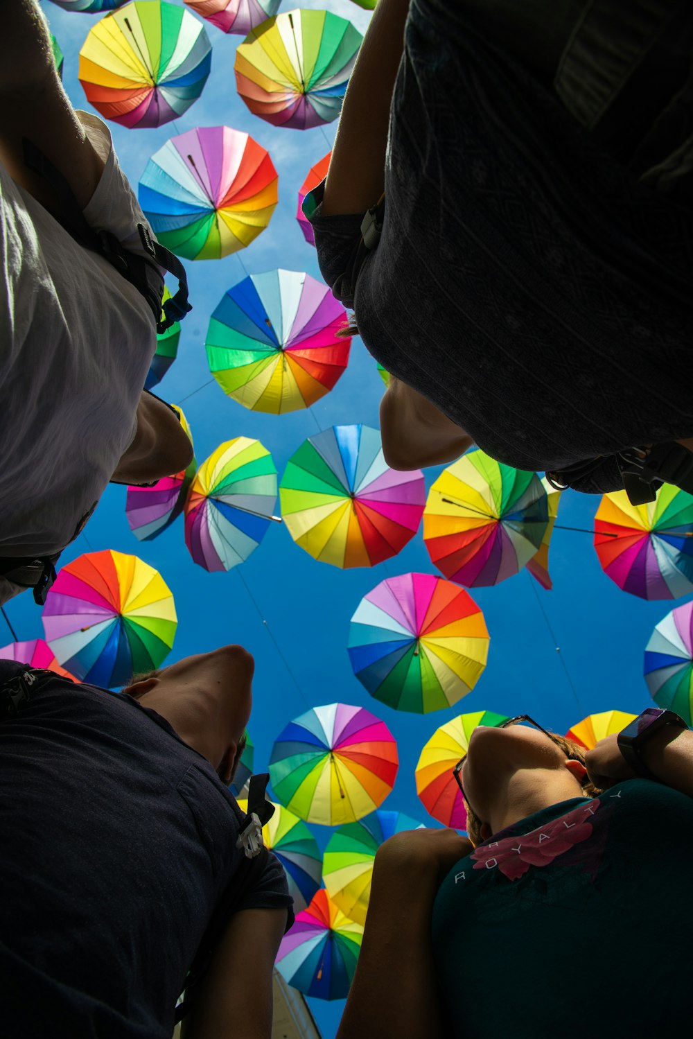 화려한 우산 아래 사람들의 로우 앵글 사진