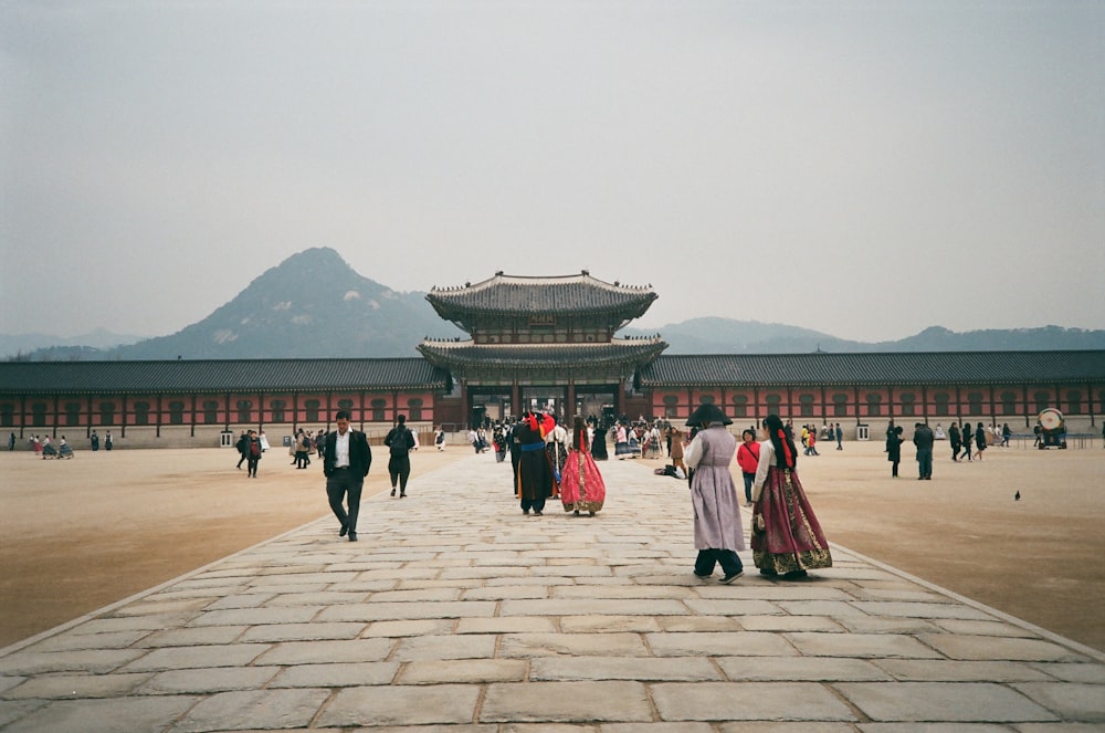 people walking in front of brown and grey building